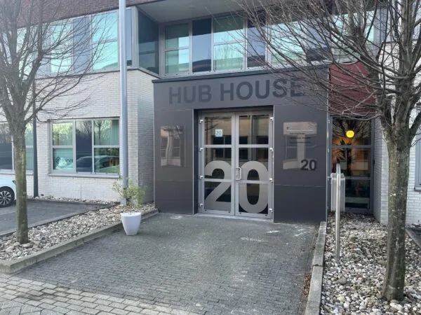 Ingang van een kantoorgebouw met de naam 'HUB HOUSE' en huisnummer 20.